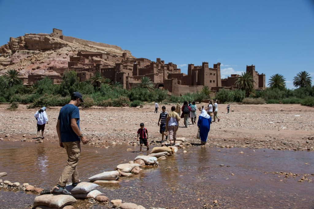 a group of people walking across a river